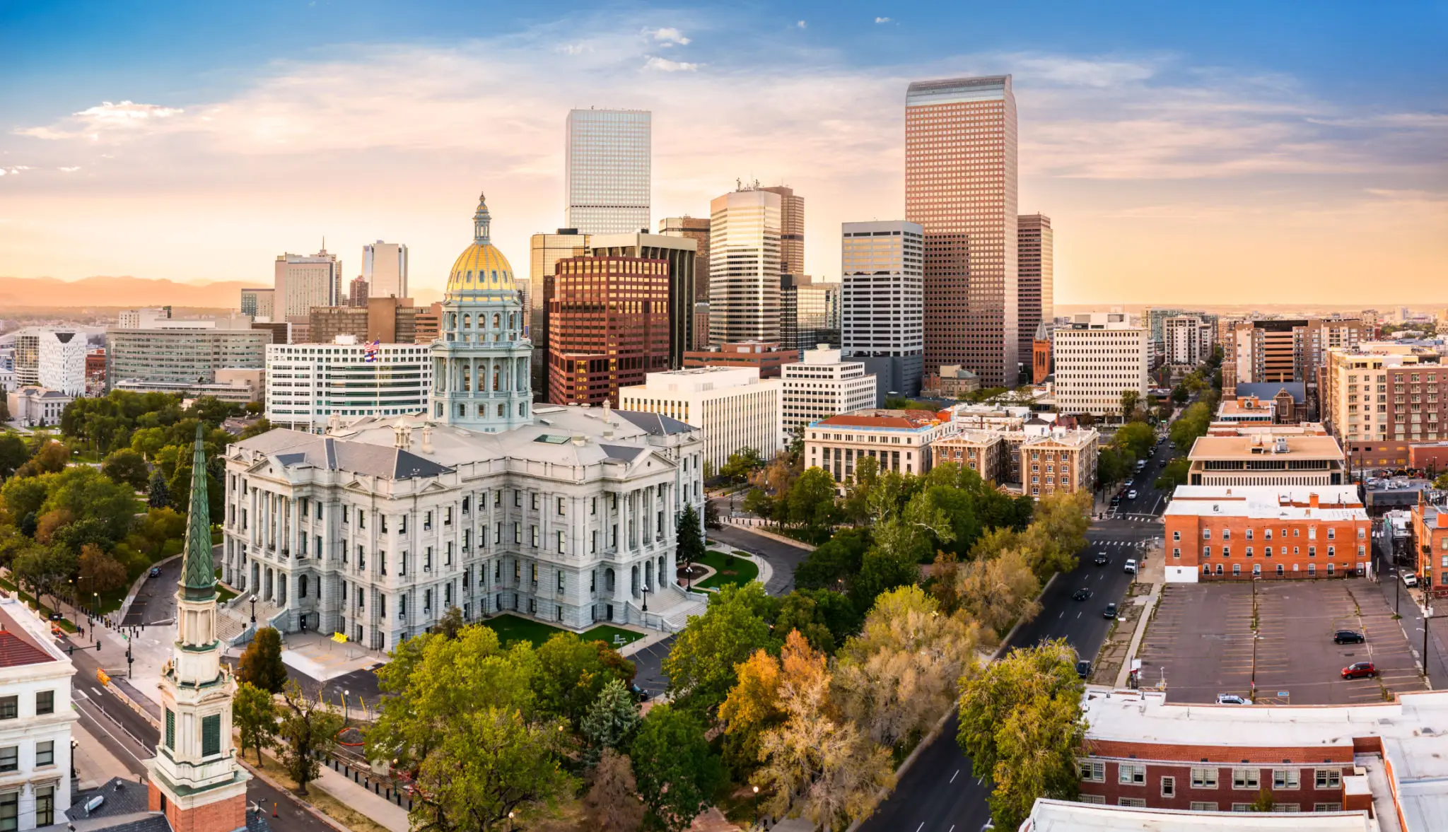 City skyline with historic and modern buildings at sunset.