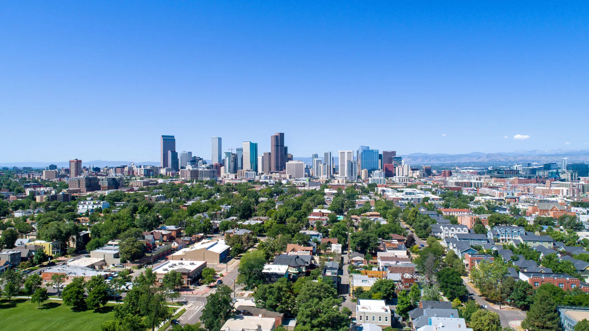 City skyline with clear blue sky and residential area in the foreground.