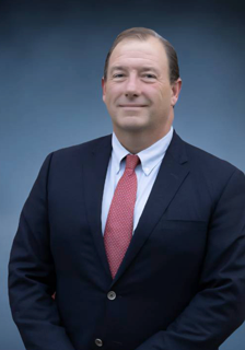Man in dark suit with red tie